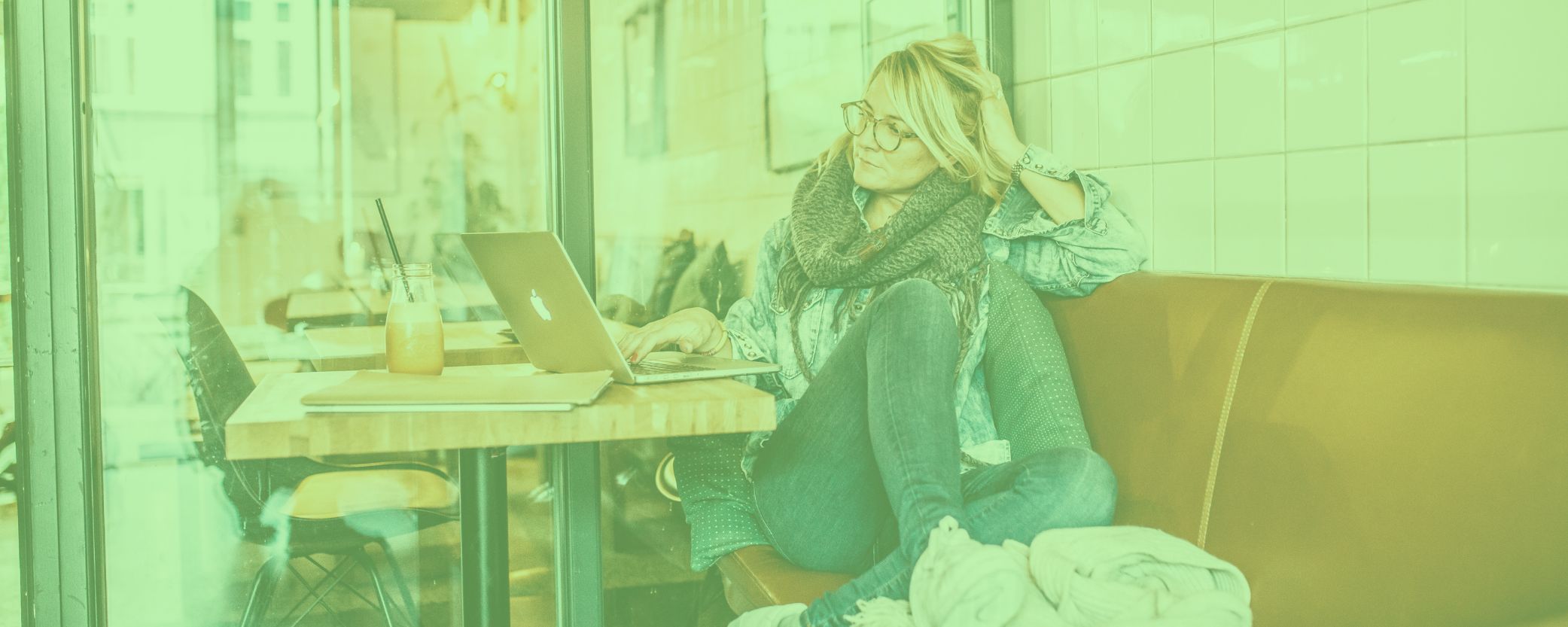 Kvinde sidder på cafe med sin computer